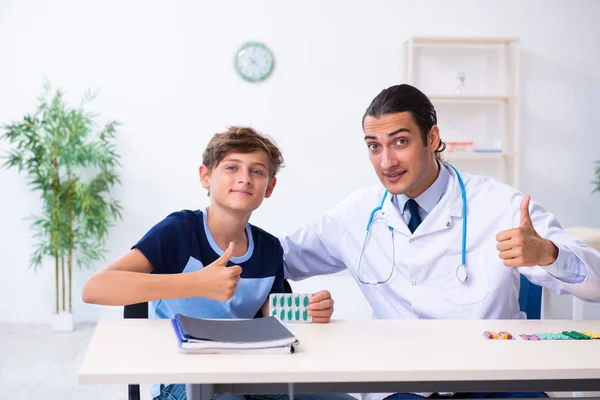Jonge mannelijke arts onderzoeken jongen in de kliniek — Stockfoto