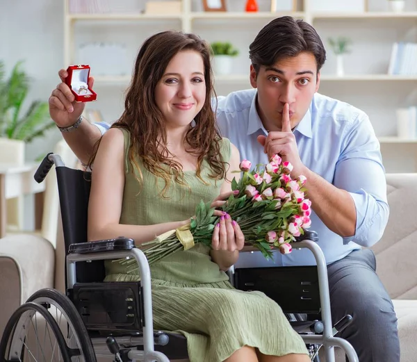 Uomo che fa la proposta di matrimonio alla donna disabile sulla sedia a rotelle — Foto Stock
