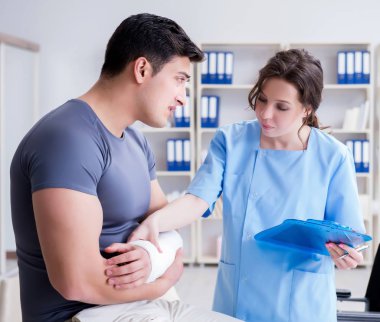 Hastanede yaralanma kontrolü sırasında doktor ve hasta.