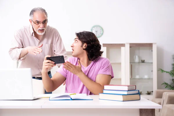 Oude vader helpt zijn zoon bij de voorbereiding van het examen — Stockfoto