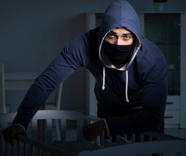 İnsan çocuk ticareti konseptinde bebek çalan suçlu.