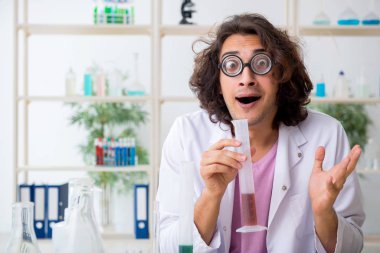 Laboratuvarda çalışan komik erkek kimyager.