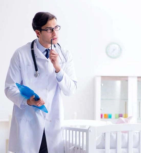 El hombre pediatra masculino cerca de la cuna preparándose para examinar — Foto de Stock