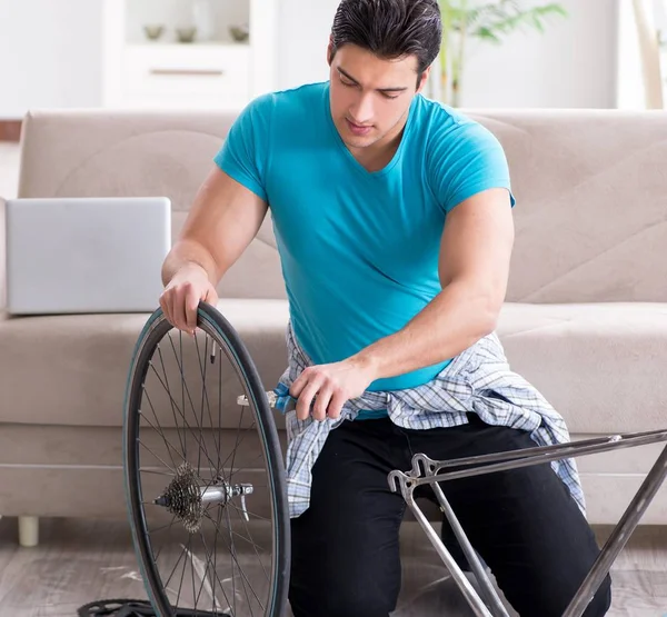 Fiatal férfi kerékpárjavítás otthon — Stock Fotó