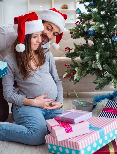 Jeune famille attend bébé célébrant Noël — Photo