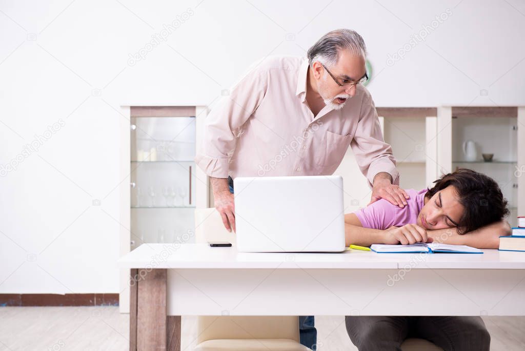 Old father helping his son in exam preparation