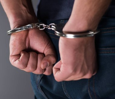 Man with his hands handcuffed in criminal concept clipart