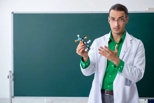 Nuori kemisti opettaja edessä liitutaulu — kuvapankkivalokuva
