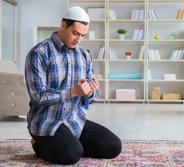 Jovem muçulmano rezando em casa — Fotografia de Stock
