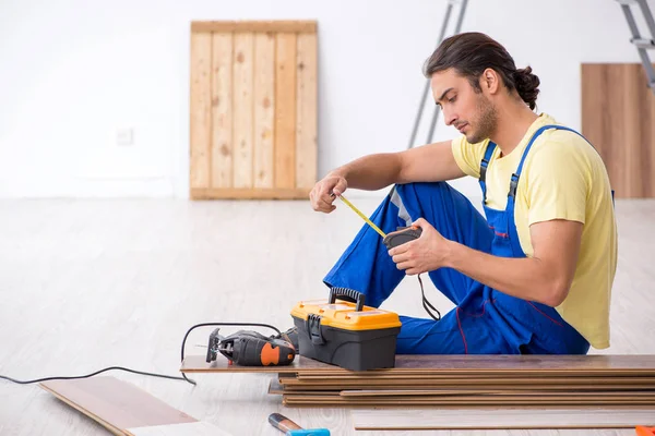 Jovem empreiteiro do sexo masculino trabalhando dentro de casa — Fotografia de Stock