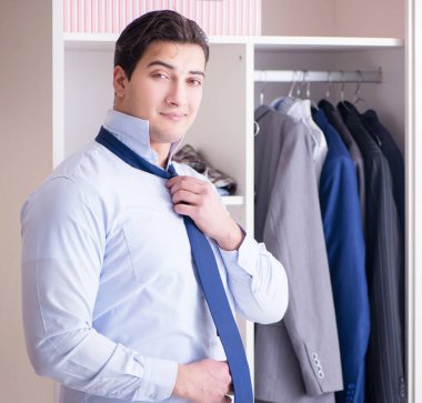 Genç işadamı iş için giyiniyor.