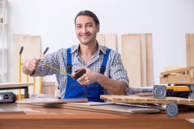 Genç erkek marangoz içeride çalışıyor.