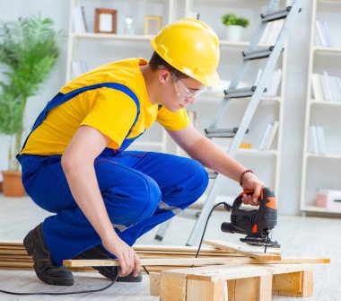 Ahşap palet montajı yapan genç adam.