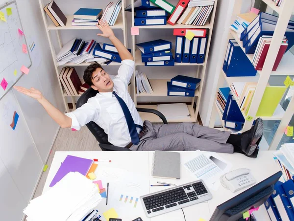 Empresario trabajando en la oficina con montones de libros y papeles — Foto de Stock