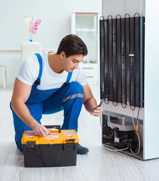 Reparador contratante reparação de geladeira no conceito DIY — Fotografia de Stock