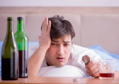 Yatakta içen alkolik adam depresyona giriyor.