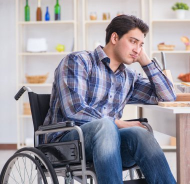 Engelli genç koca mutfakta çalışıyor.