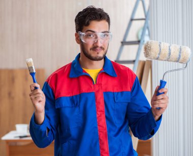 Yooung marangoz boyayla uğraşıyor.