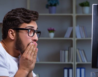 Genç adam fazla mesai yapmak için geç saatlere kadar ofiste kalıyor.