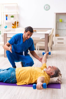 Genç erkek doktor eski hastayı ziyaret ediyor.