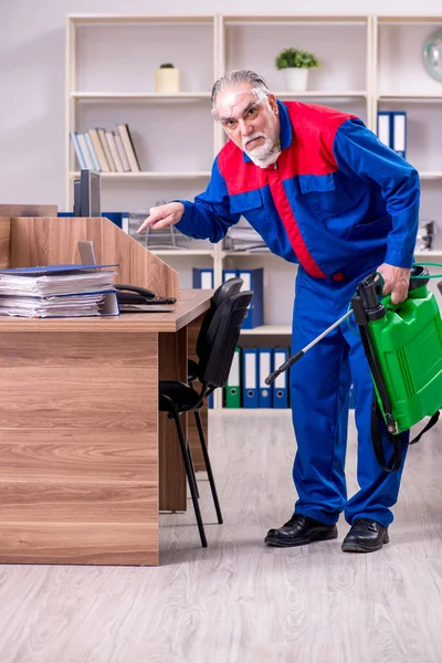 Oude professionele aannemer doet ongediertebestrijding in het kantoor — Stockfoto