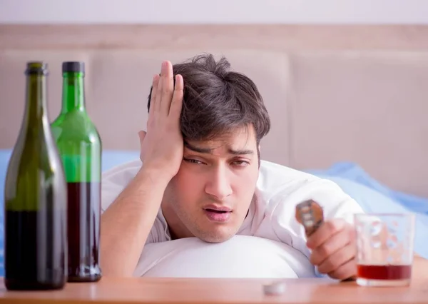 Man alkoholhaltiga drycker i sängen går igenom bryta upp depression — Stockfoto