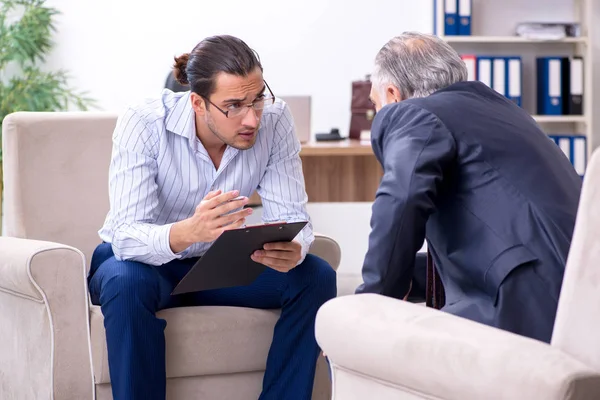 Old man visiting young male doctor psychologist — Stock Photo, Image