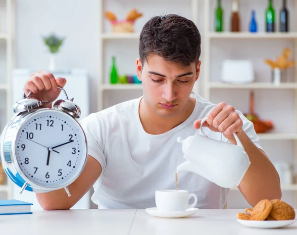 Muž s budíkem při snídani usíná — Stock fotografie