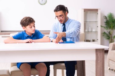 Baba oğlunun sınava hazırlanmasına yardım ediyor.