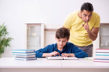 Baba oğlunun okula hazırlanmasına yardım ediyor.