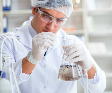 Genç araştırmacı bilim adamı bir su testi kirliliği araştırması yapıyor.