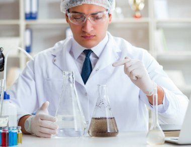 Genç araştırmacı bilim adamı bir su testi kirliliği araştırması yapıyor.