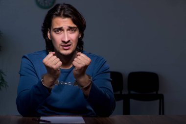 Genç mahkum karanlık odada oturuyor.