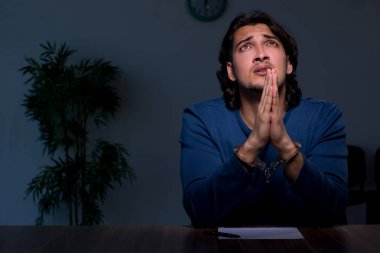 Genç mahkum karanlık odada oturuyor.