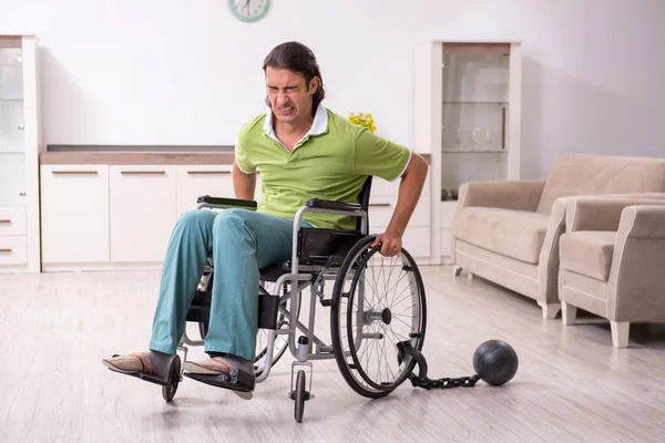 Молодий чоловік нечинний в інвалідному візку страждає вдома — стокове фото