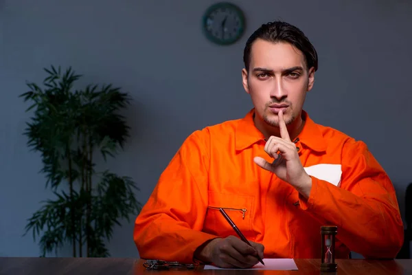 Jonge veroordeelde man zit in donkere kamer — Stockfoto