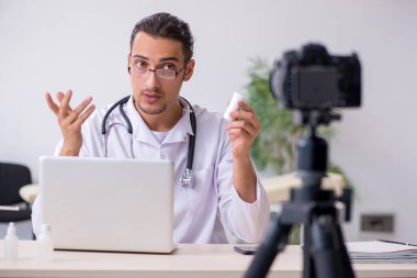 Genç erkek doktor blogu için video kaydediyor.