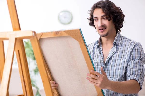 Jovem homem bonito curtindo pintura em casa — Fotografia de Stock