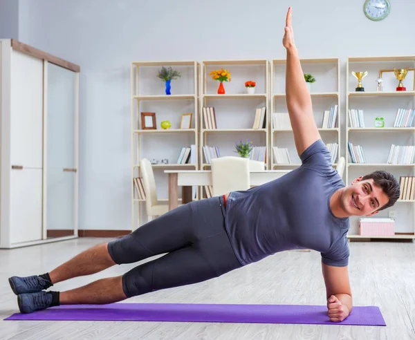 Joven haciendo ejercicio en casa en deportes y estilo de vida saludable con — Foto de Stock