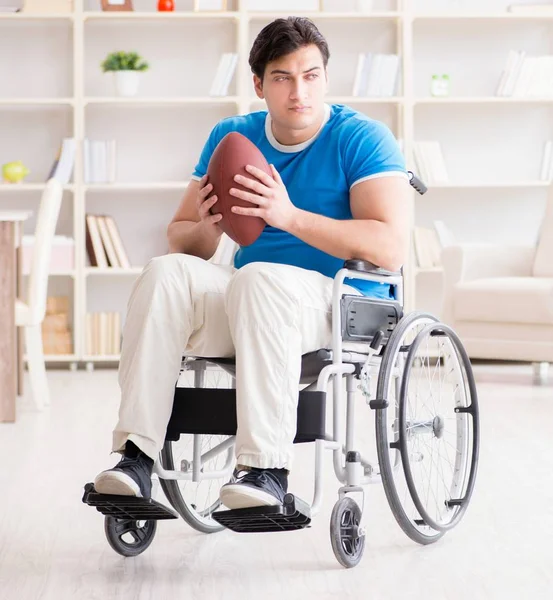 Jovem jogador de futebol americano se recuperando em cadeira de rodas — Fotografia de Stock