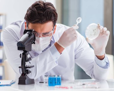 Laboratuvarda virüs aşısı üzerinde çalışan erkek doktor.