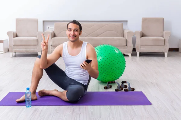 Jovem treinando e exercitando em casa — Fotografia de Stock