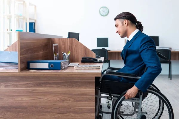 Jovem empregado do sexo masculino em cadeira de rodas — Fotografia de Stock