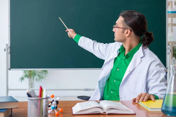 Mladý muž chemik učitel před tabulí — Stock fotografie