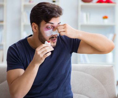 Genç adam estetik cerrahi burnundan sonra evde iyileşiyor.