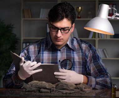 Arkeolog geç saatlere kadar ofiste çalışıyor.