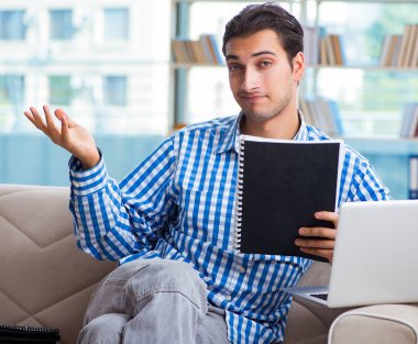 Bilgisayarlı beyaz öğrenci üniversite sınavlarına hazırlanıyor.