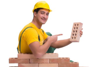 Yakışıklı inşaat işçisi tuğla duvar inşa ediyor.