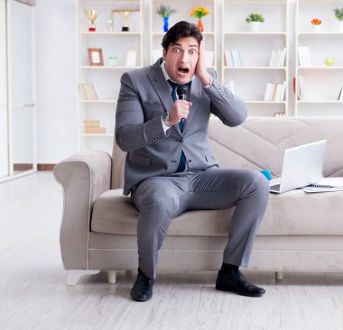 Üzgün işadamı ofiste şarkı söylüyor.