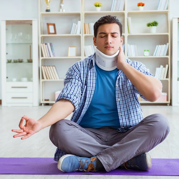 L'uomo con lesioni al collo che medita a casa sul pavimento — Foto Stock